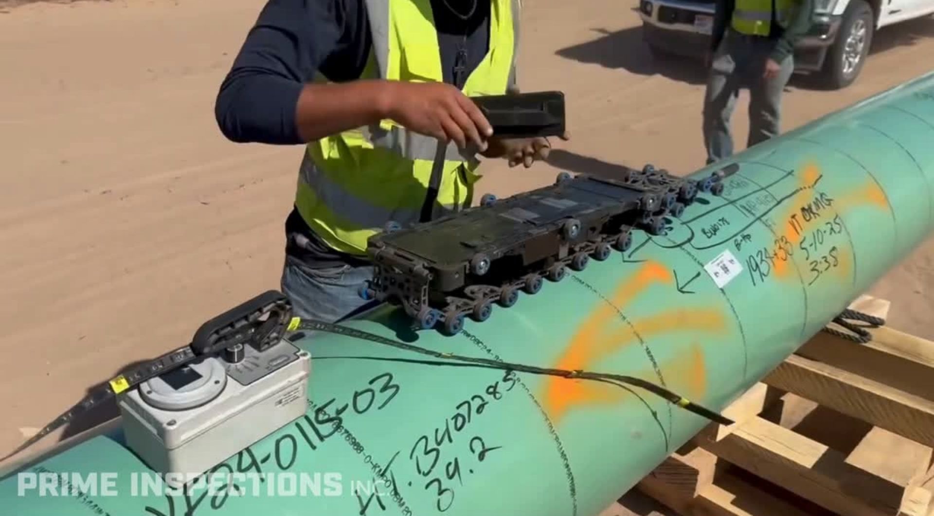 Prime technician setting an automated ultrasonic scanner on a pipeline girth weld