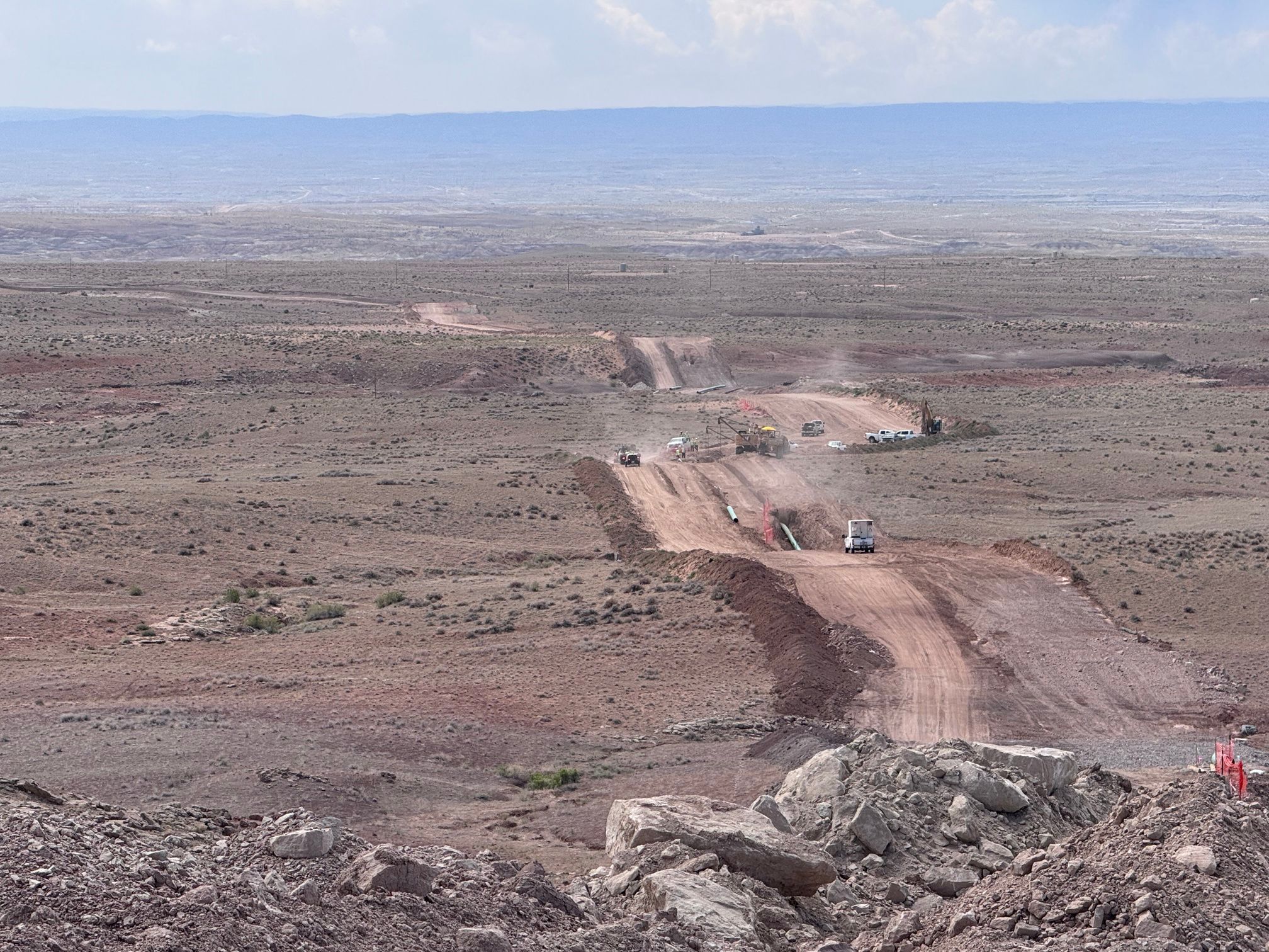 Aerial view of a pipeline right-of-way with pipe strung along the row