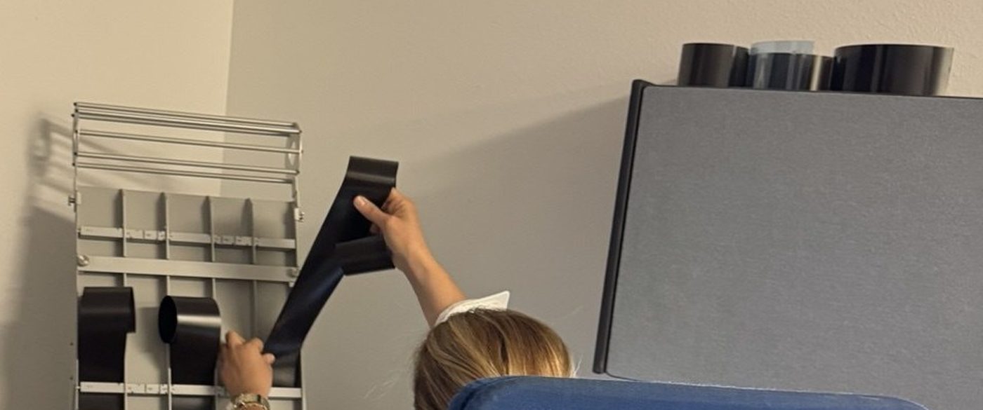 Technician feeding radiographic weld film into a film digitizer