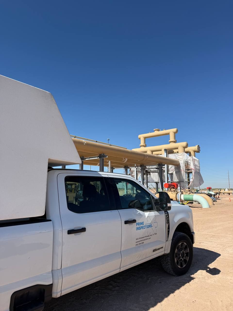 Prime Inspections darkroom truck parked at above-ground station piping under construction