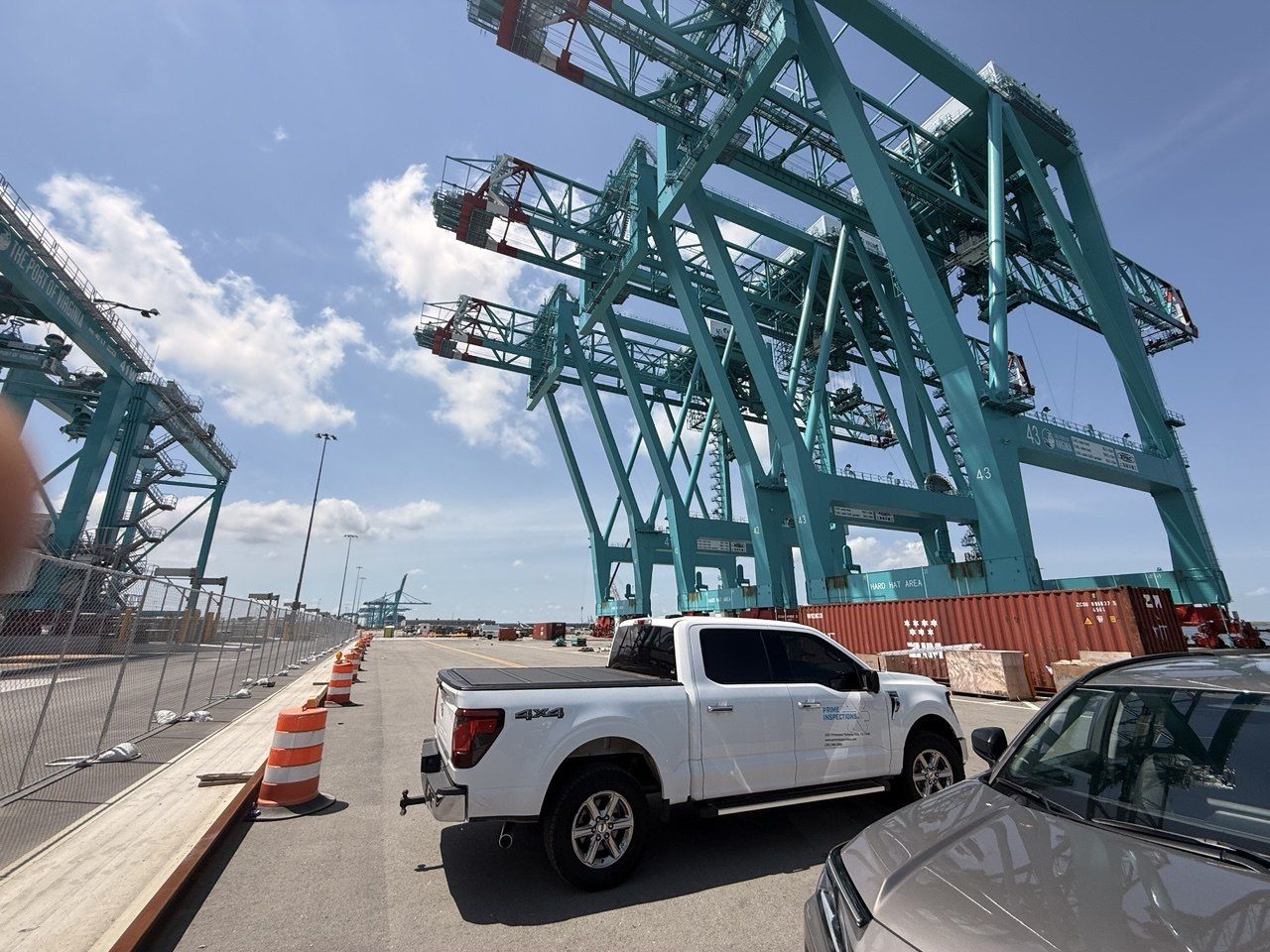 Prime Inspections truck at an industrial marine terminal beneath container cranes