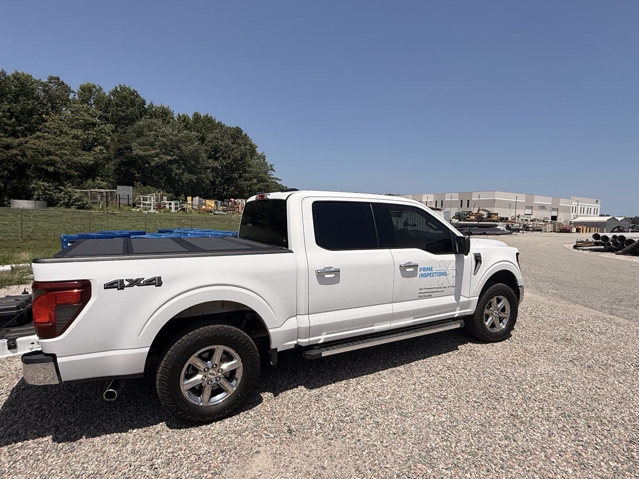 Prime Inspections truck parked on a gravel yard beside an industrial building
