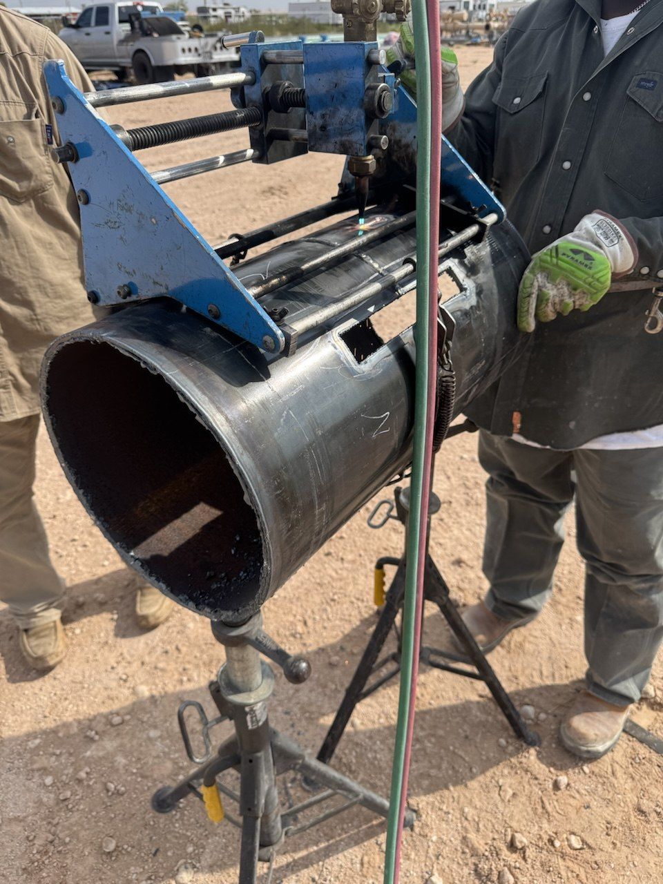 Cutting machine mounted on a pipe test weld, with specimen coupons already cut out of the weld